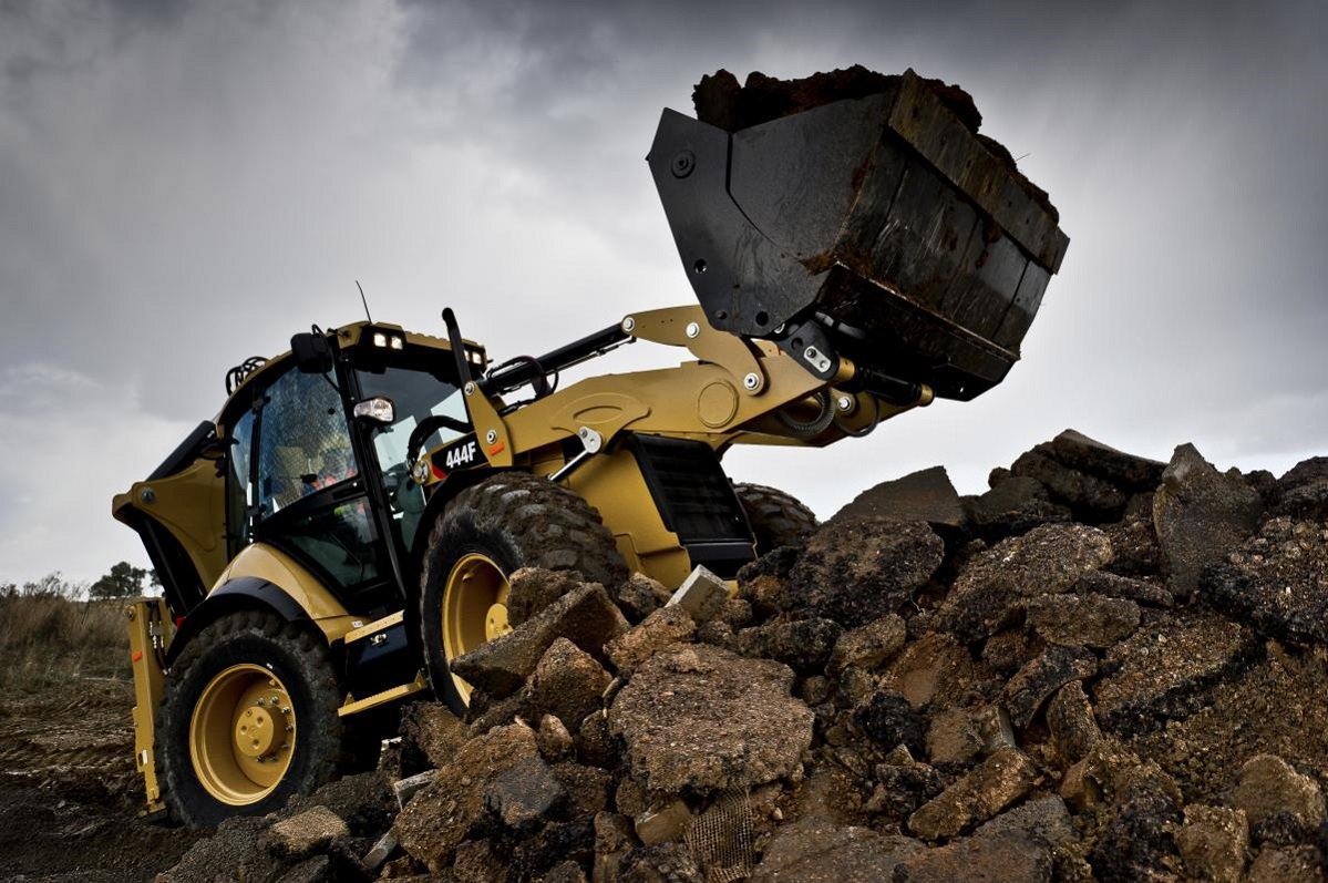 Экскаватор-погрузчик Caterpillar 444F с челюстным ковшом