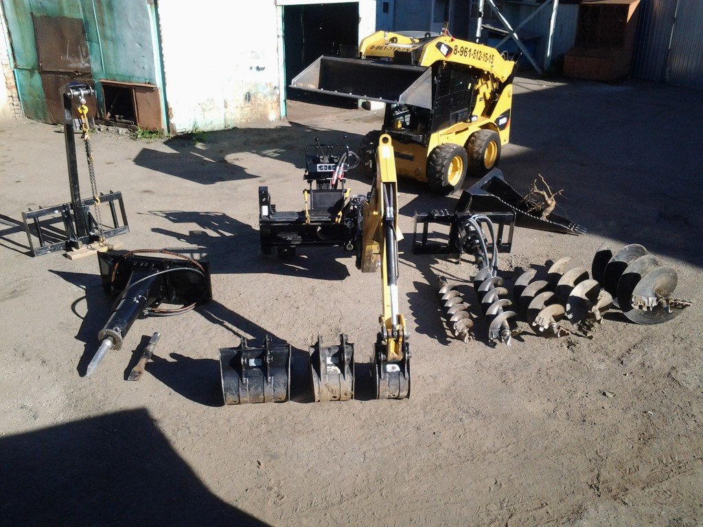 Минипогрузчик Caterpillar с буровой установкой в парке